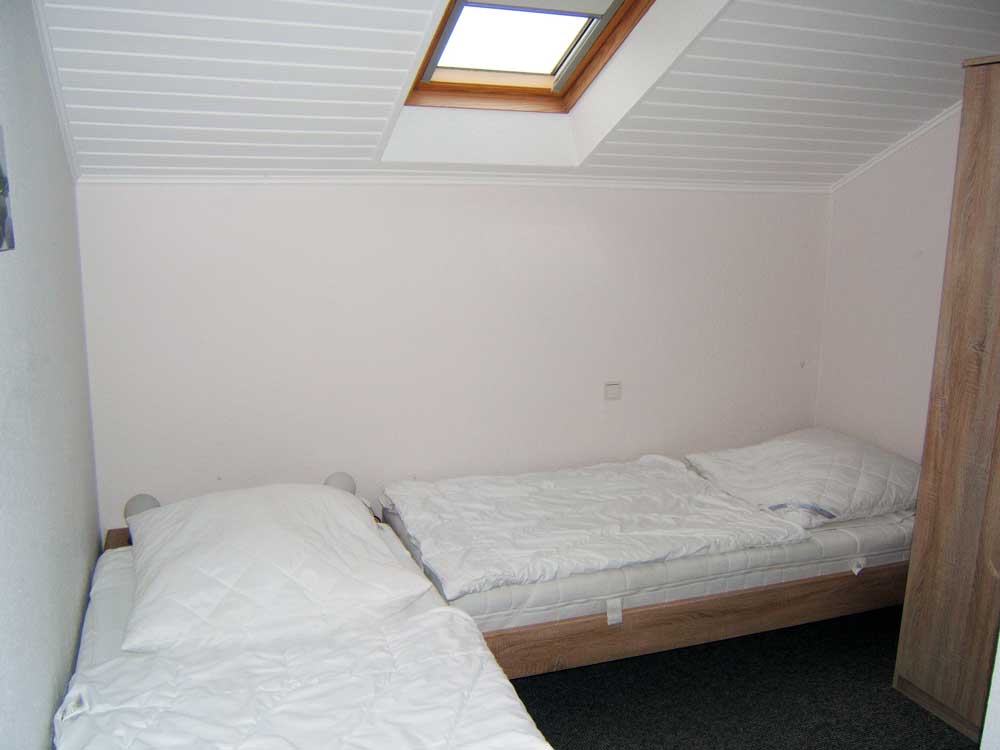 Schlafzimmer 2 (Dachgeschoss): 2 Einzelbetten (jeweils 0,9 x 2 m) mit Beistelltischchen, Kleiderschrank