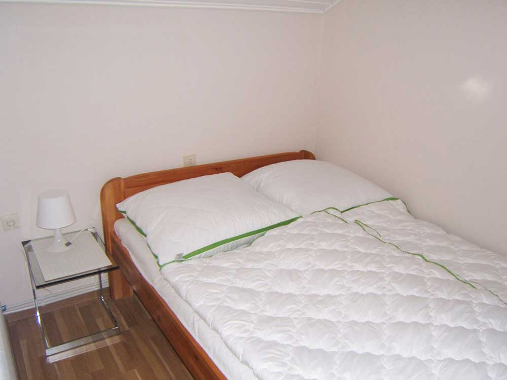 Schlafzimmer 1 (Dachgeschoss): Doppelbett (1,40 x 2 m) mit Beistelltischchen, Kleiderschrank