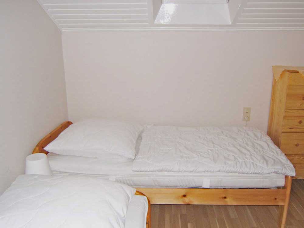 Schlafzimmer 2 (Dachgeschoss), 2 Einzelbetten (jeweils 0,90 x 2 m) mit Beistelltischchen, Kommode