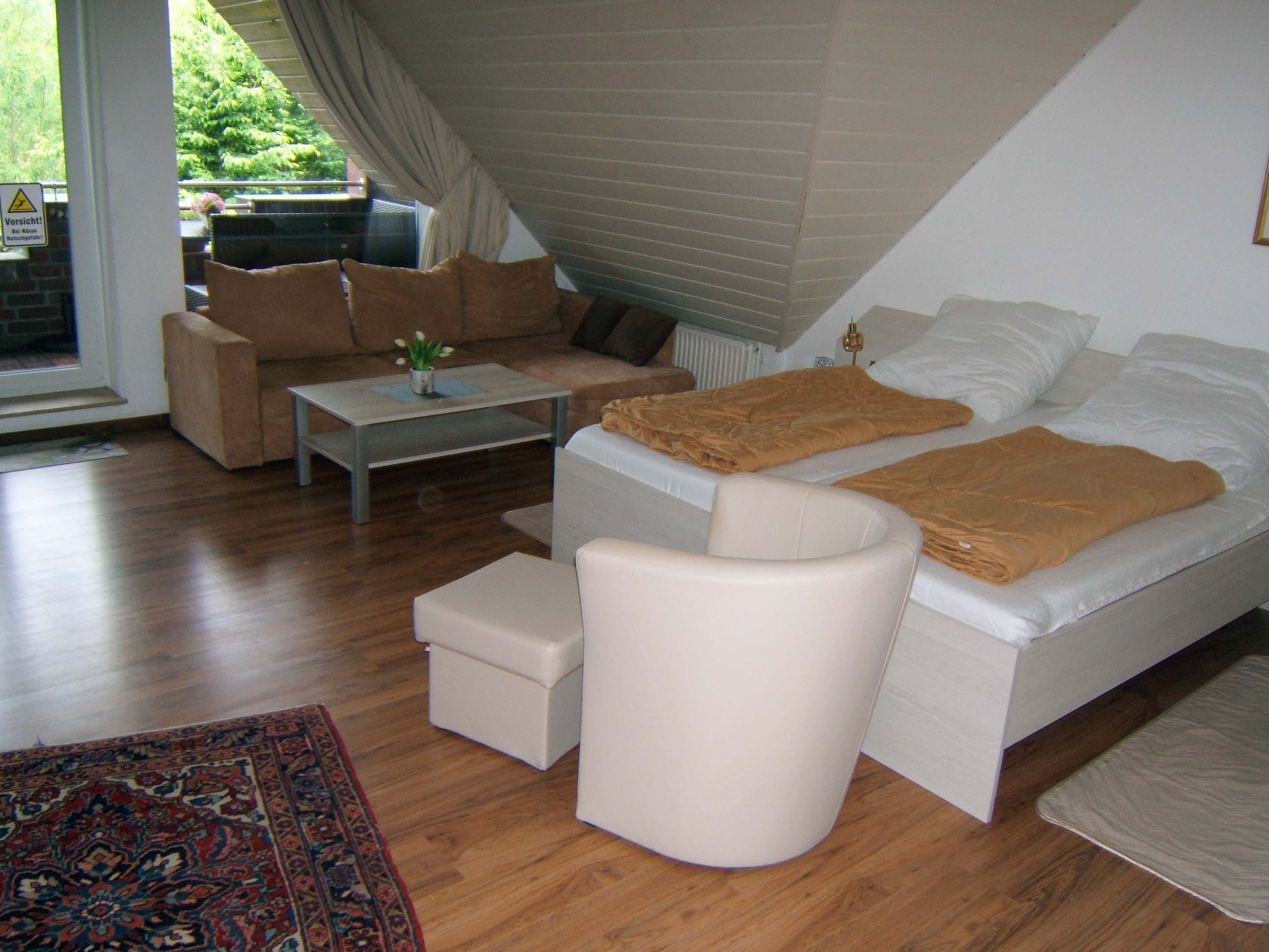 Wohn-Schlafraum: gemütlich mit großer Wohncouch und Sessel, separatem Essplatz, Loggia mit Gartenmöbel